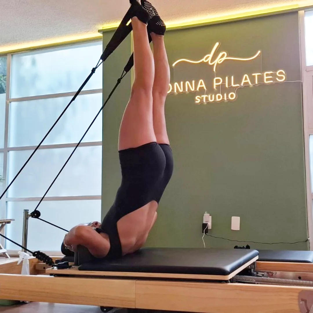 Persona practicando pilates reformer dentro de Donna Pilates Studio
